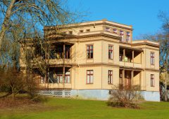 Ronneby, Sweden - February 26, 2016: The Italian villa is a heritage listed building from 1881, built to accommodate rich guests and their servants during spa visits. Two unknown persons on balcony.